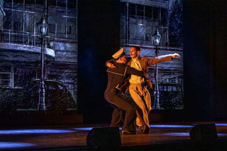 Två män (en i sjömanskostym) dansar tillsammans på scenen i musikalen Tom of Finland.