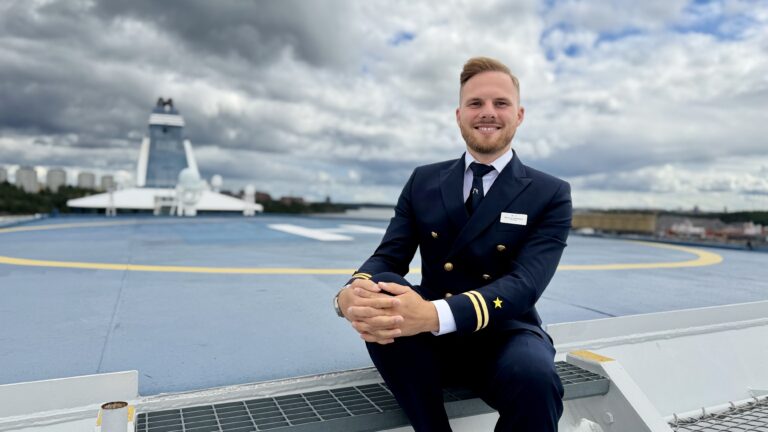 Riche Johansson är styrman på Silja Symphony, här sitter han ute på däck i kaptenskläder, redo att segla ut.