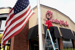 Snabbmatskedjan Chick- fil- a och en amerikansk flagga som halas.