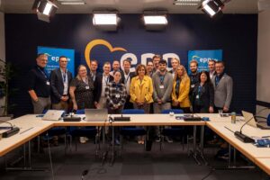 Gruppbild med EPPride-medlemmar i konferensrum med logotyp