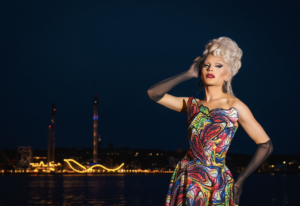 Dragqueen mot Stockholmssilhuett.