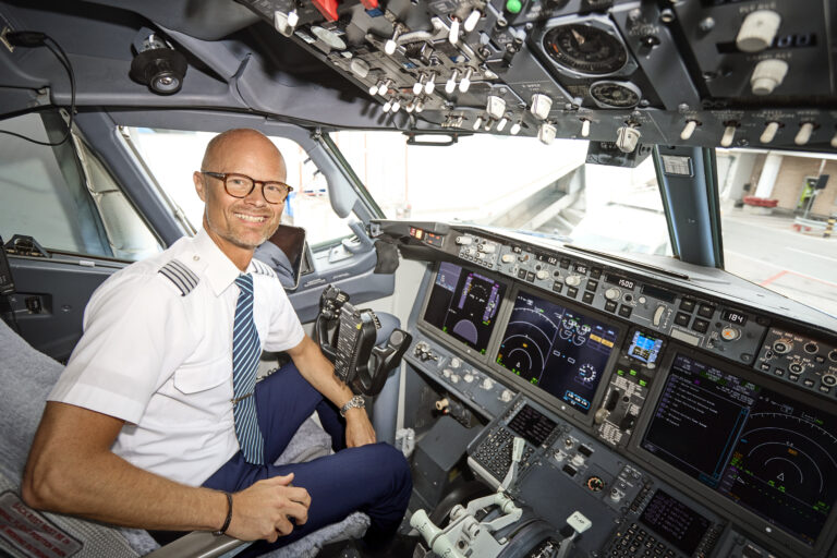Markus sitter i kortärmad skjorta i planets cockpit inför starten